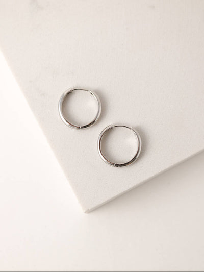 Two silver-plated 20mm hoop earrings with a smooth finish, placed on a neutral background to highlight their simple, timeless design.