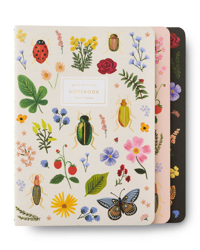 Set of three Rifle Paper Co. assorted journals featuring vibrant botanical and insect illustrations on softcover designs, with ruled pages for writing and note-taking.