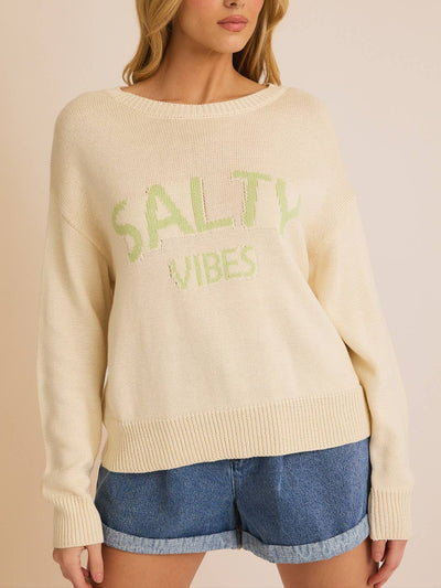 A cream-colored lightweight sweater with 'Salty Vibes' text in light green, featuring a relaxed fit, round neckline, and soft knit fabric, perfect for beach lovers and coastal fashion.