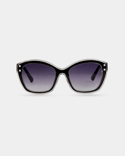 A pair of oversized black and clear cat-eye sunglasses with rhinestone accents on the corners, featuring dark gradient lenses for a glamorous and stylish look.